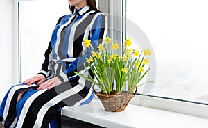 Beautiful woman with a flower basket full of Narcissus