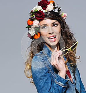 Beautiful woman in flower crown holding sunglasses