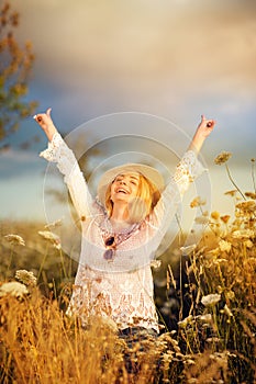 Beautiful woman in a flower meadow with sunhat and sunglasses, lust for life
