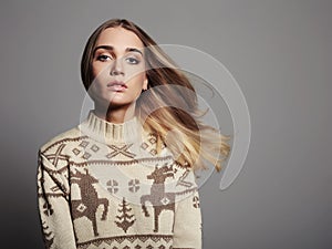 Beautiful Woman with flying hair in winter pullover. Beauty Blond Girl