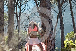 Woman dancing in a forest flicking her hair with trees in the background.