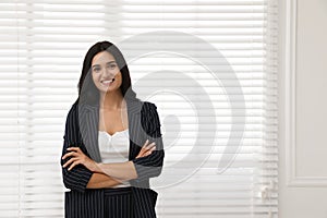 Beautiful woman in formal suit near window, space for text. Business attire