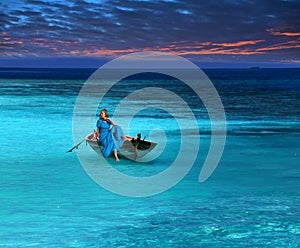 Beautiful woman in the fragile boat in a stormy sea