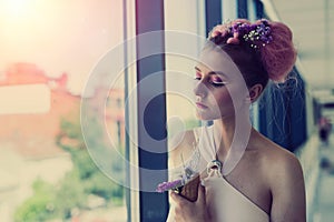 Beautiful woman with fresh makeup posing near window