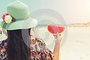 Beautiful woman with fresh watermelon with in hands on tropical beach - vacation in summer