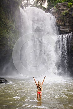 A beautiful woman in front of Tegenungan waterfall in bali photo