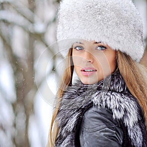 Beautiful woman in furry hat in winter - close up