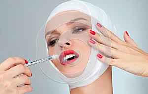 Beautiful woman get injection in lips with bandaged face. Beauty, Fashion and Plastic Surgery concept