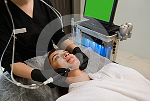 Beautiful woman getting facial hydro microdermabrasion peeling treatment at spa center. Hydra Vacuum Cleaner. Exfoliation,