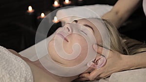 Beautiful woman getting facial massage in spa. Facial skin care in beauty saloon.