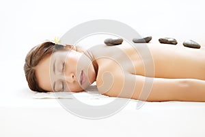 Beautiful Woman Getting Hot Stone Massage in Spa Salon. Beauty t