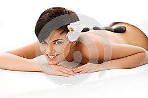 Beautiful Woman Getting Hot Stone Massage in Spa Salon. Beauty t