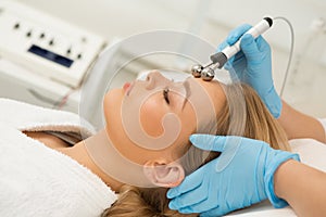 Beautiful woman getting microcurrent facial treatment at the beauty clinic