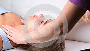 Beautiful woman getting neckline massage in beauty salon.