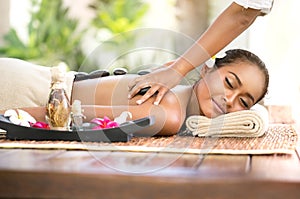 Beautiful woman getting spa hot stones massage in spa salon