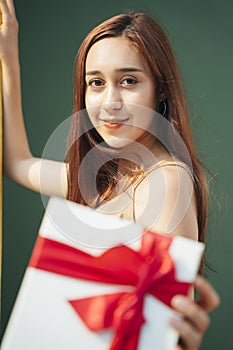 Beautiful woman with gift box from santa over green background