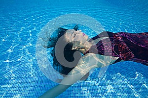 Beautiful woman girl dress underwater diving swim blue sunny day pool