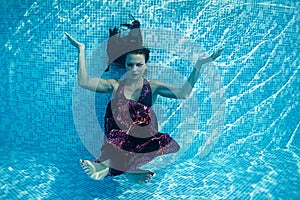 Beautiful woman girl dress underwater diving swim blue sunny day pool