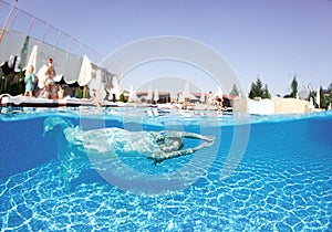 Beautiful woman girl white dress underwater diving swim blue sunny day pool