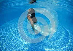 Beautiful woman girl white dress underwater diving swim blue sunny day pool