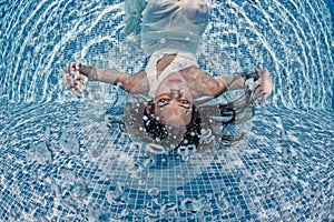 Beautiful woman girl white dress underwater diving swim blue sunny day pool