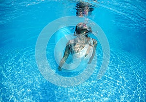 Beautiful woman girl white dress underwater diving swim blue sunny day pool