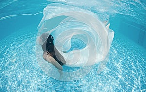 Beautiful woman girl white dress underwater diving swim blue sunny day pool