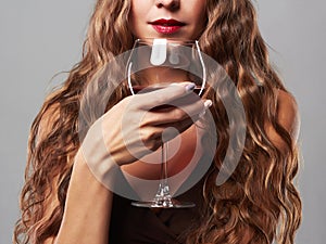 Beautiful woman with glass red wine. curly hairstyle