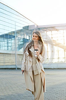 Beautiful Woman Going To Work With Coffee Walking Near Office Building. Portrait Of Successful Business Woman Holding Cup Of Hot D