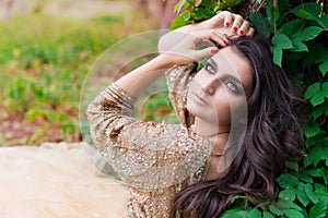 Beautiful woman in gold dress is looking to the sky