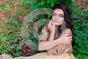 Beautiful woman in gold dress is sleeping and hugging herself