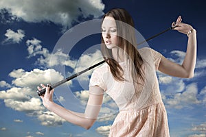 Beautiful woman with golfclub looks down at right