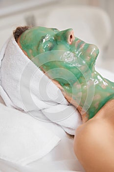 beautiful woman with green alginate mask on face