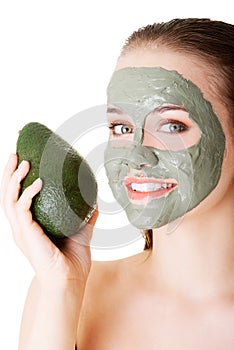 Beautiful woman with green avocado clay facial mask