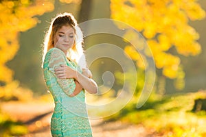 Beautiful Woman in green dress on Fall Nature Background