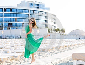 Beautiful woman in a green gown on the beach