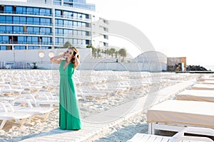 Beautiful woman in a green gown on the beach