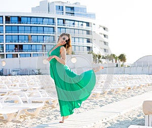 Beautiful woman in a green gown on the beach