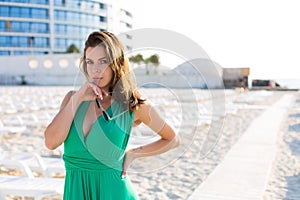 Beautiful woman in a green gown on the beach