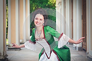 Beautiful woman in green medieval dress doing curtsey