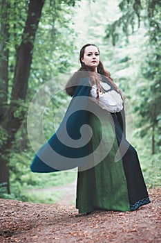 Beautiful woman in green medieval dress outdoor
