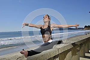 Beautiful woman in gymnist pose on beach