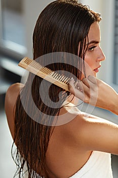 Beautiful Woman Hairbrushing Her Long Wet Hair. Hair Care