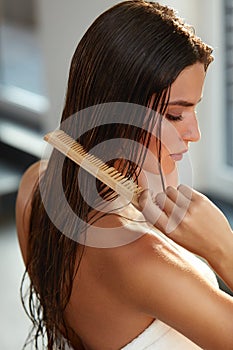 Beautiful Woman Hairbrushing Her Long Wet Hair. Hair Care