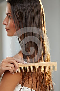 Beautiful Woman Hairbrushing Her Long Wet Hair. Hair Care