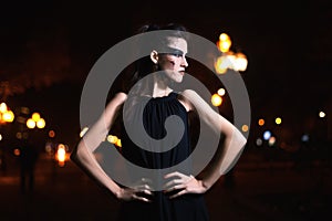 Beautiful woman with Halloween makeup posing on the street . Model looking aside. Waist up. Night city background. Toned