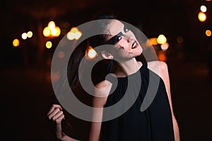 Beautiful woman with Halloween makeup posing on the street . Model looking at camera. Close up. Night city background