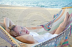 Beautiful woman in a hammock on the beach