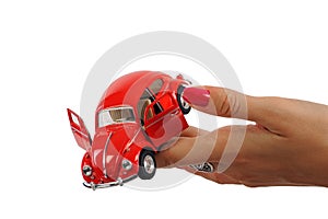 beautiful woman hand holding a red nostalgic toy car