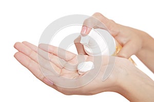 Beautiful woman hand on a white background presses on a bottle of spa cleansing foam. isolate